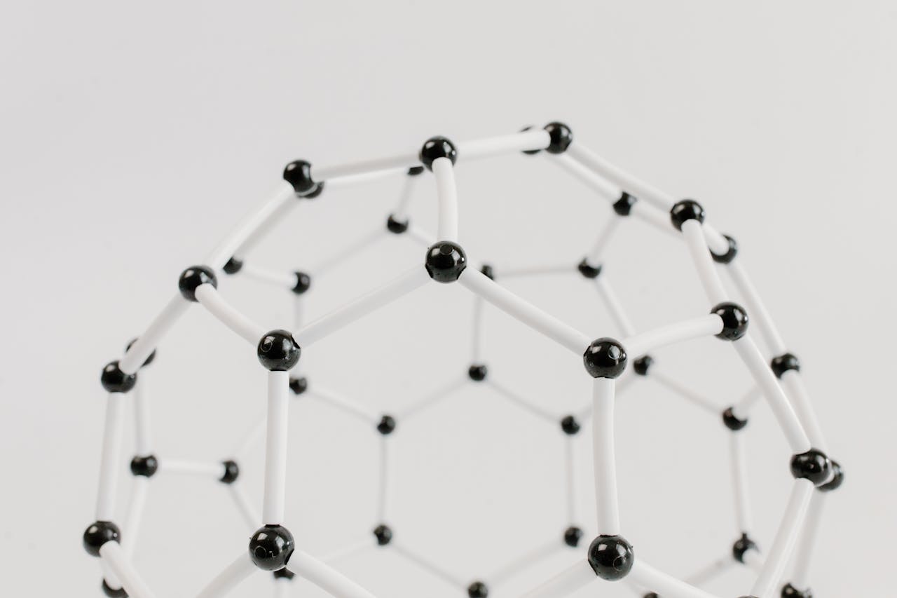 Close-up of a geometric molecular structure model with black and white connections on a light background.